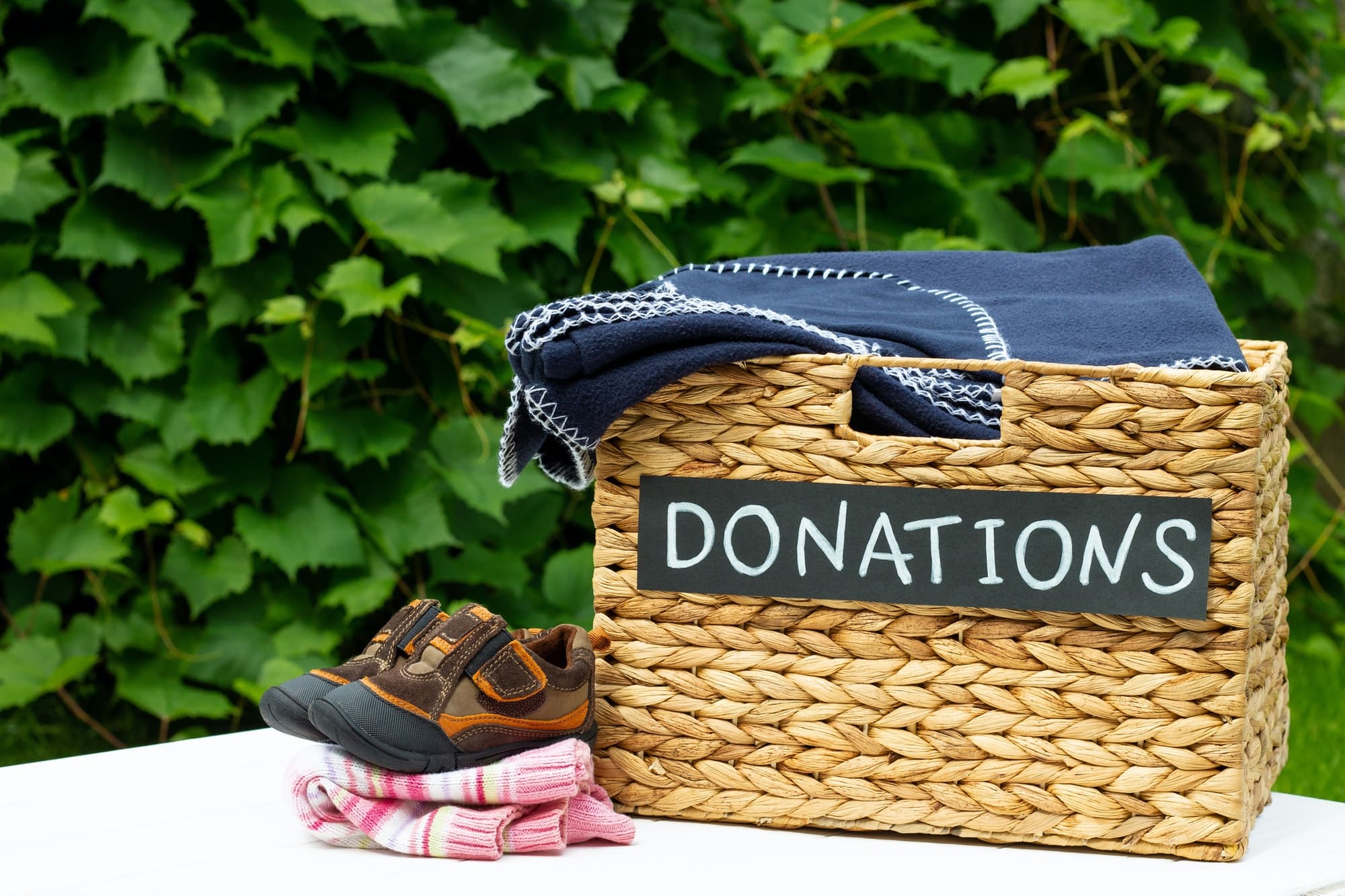 Donation box for clothing donations on a greenery background. Charity and donation concept. Copy